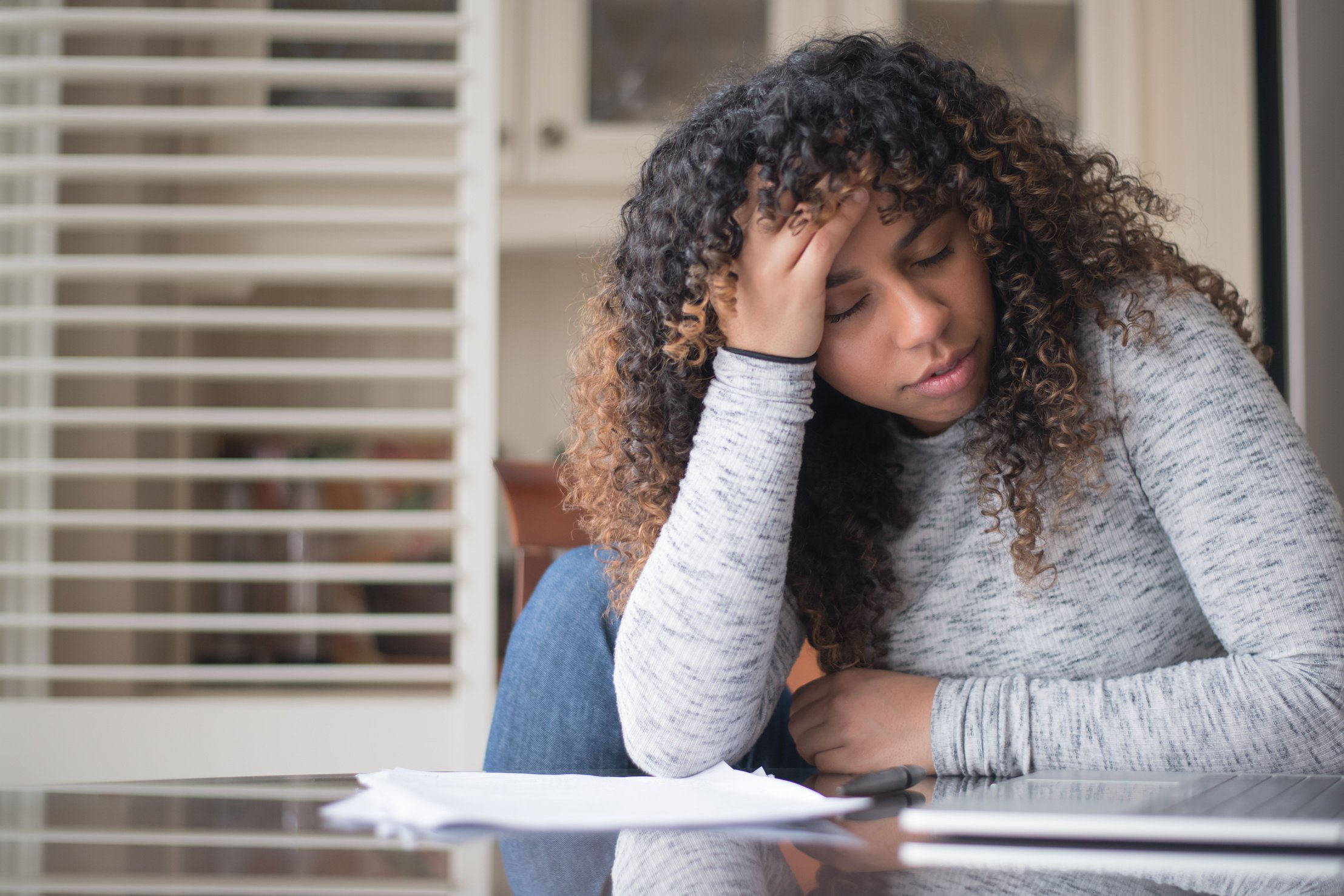 Woman of African Descent Frustrated While Doing Taxes